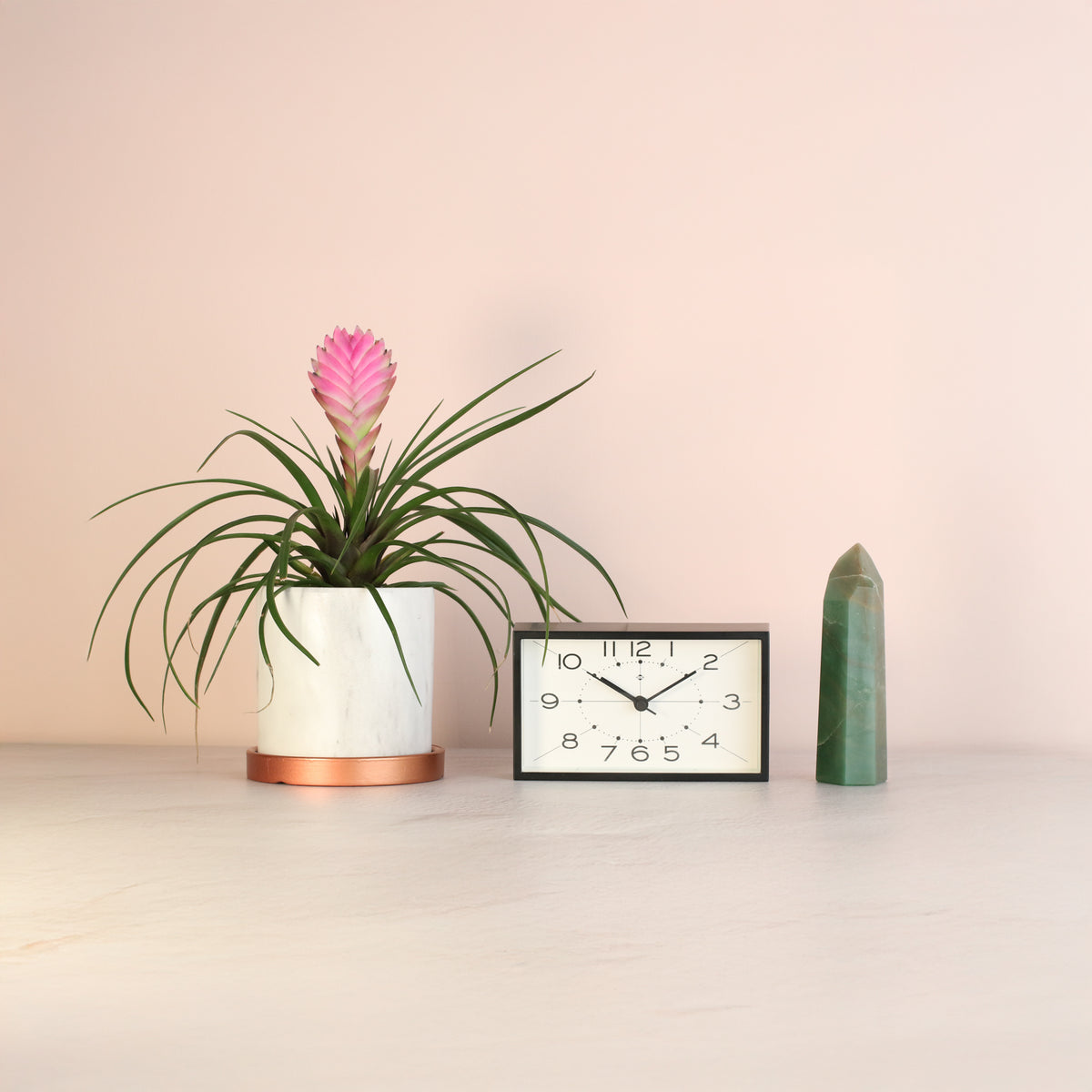 Green Aventurine Points next to clock and plant